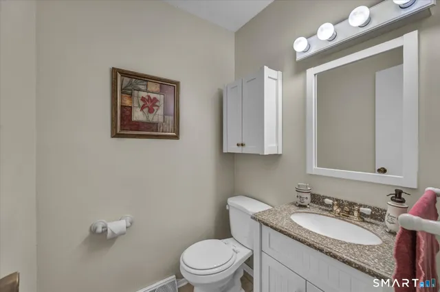 a bathroom with a toilet a sink and mirror