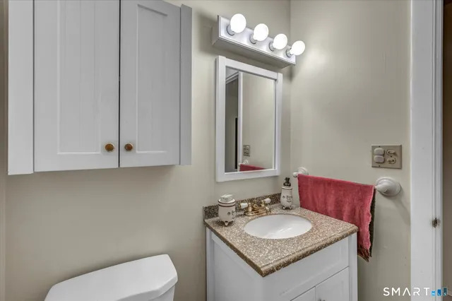 a bathroom with a toilet sink and mirror