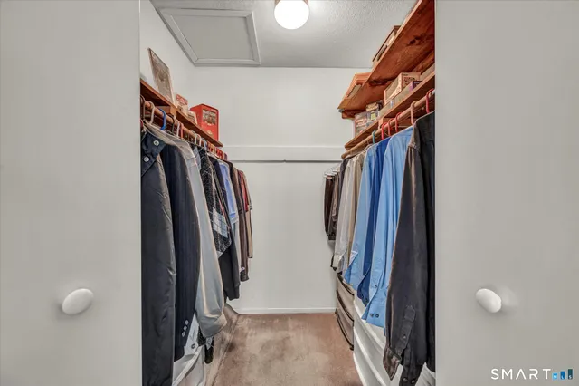 a view of walk in closet with clothes and shoes