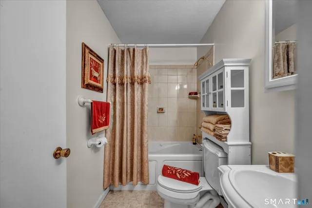 a bathroom with a toilet and a shower curtain
