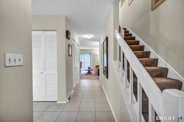 a view of a hallway with entryway and stairs