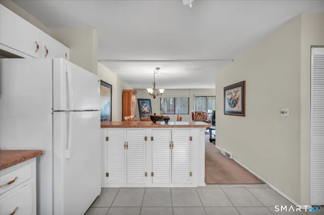 a kitchen with white cabinets and refrigerator