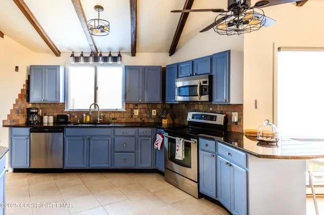 a kitchen with stainless steel appliances granite countertop a sink a stove and a microwave