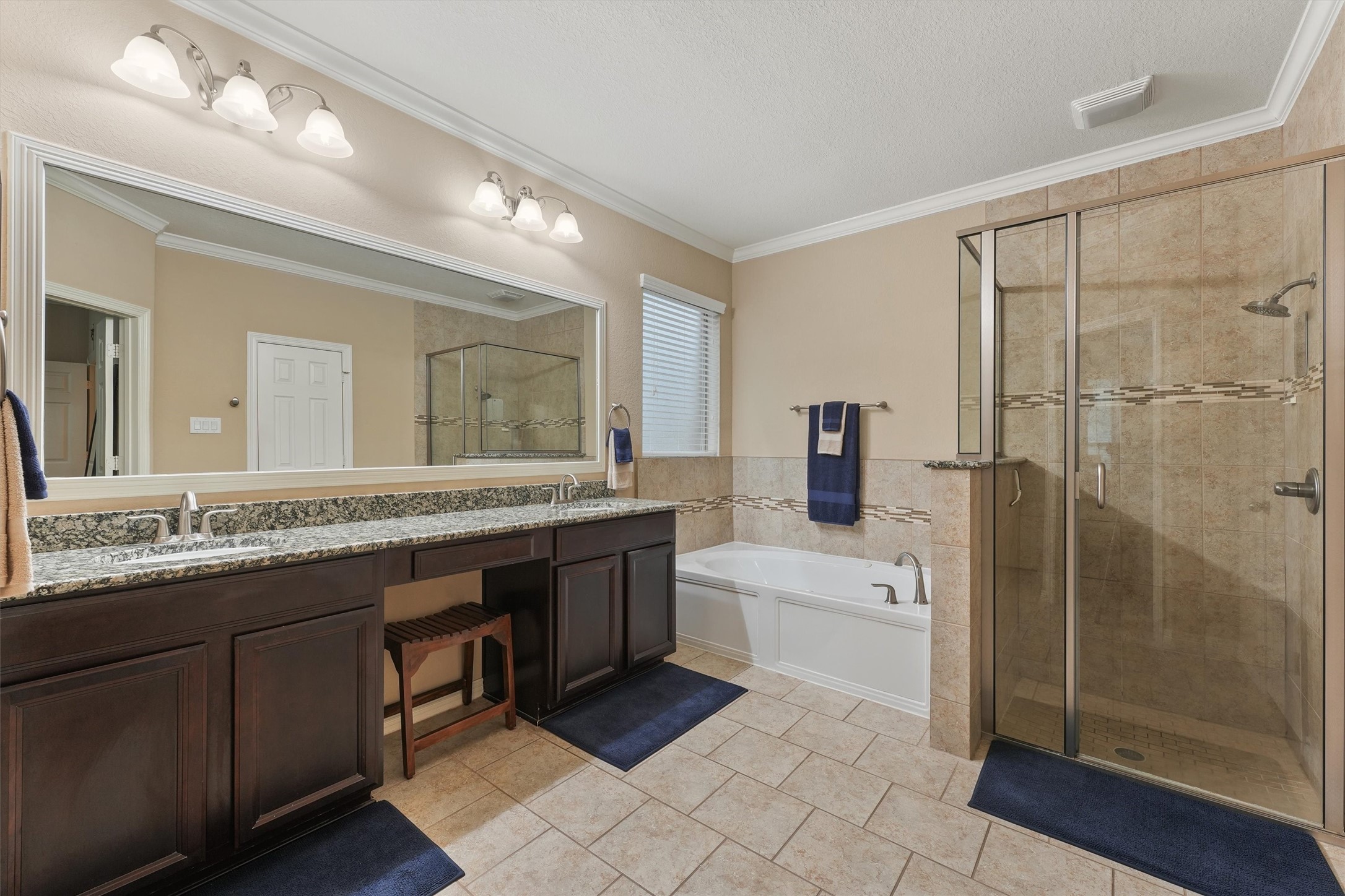 529 Water Street Webster, TX 77598 - Photo 17 of 38 a bathroom with a granite countertop double vanity sink a mirror and a bathtub