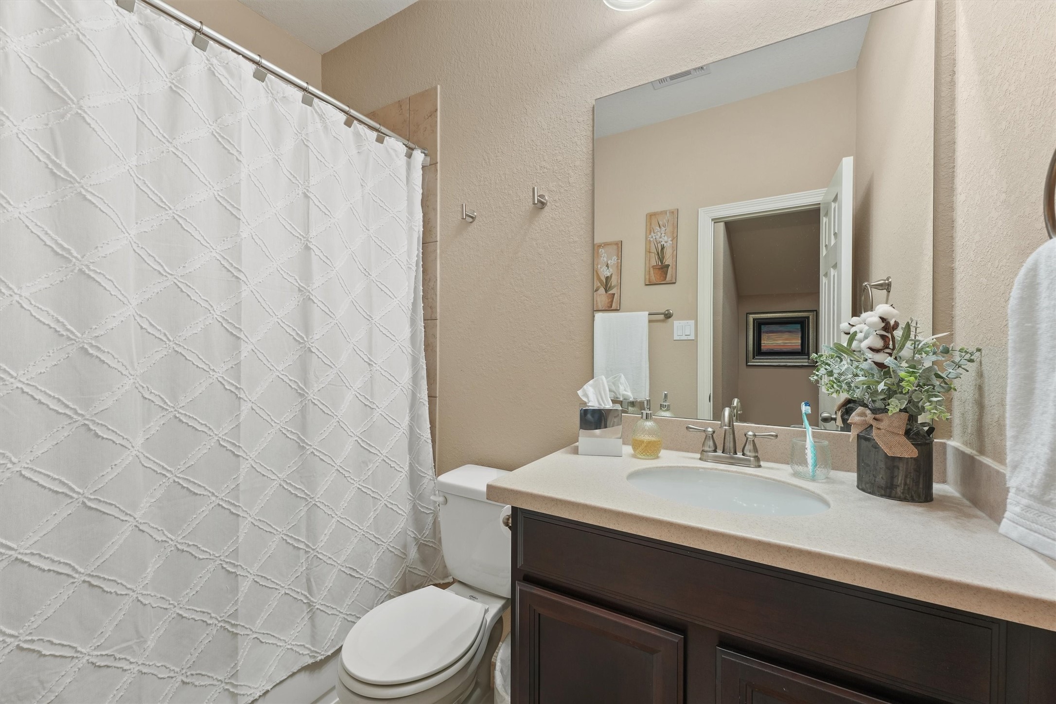 529 Water Street Webster, TX 77598 - Photo 22 of 38 a bathroom with a sink a toilet a mirror and shower curtain