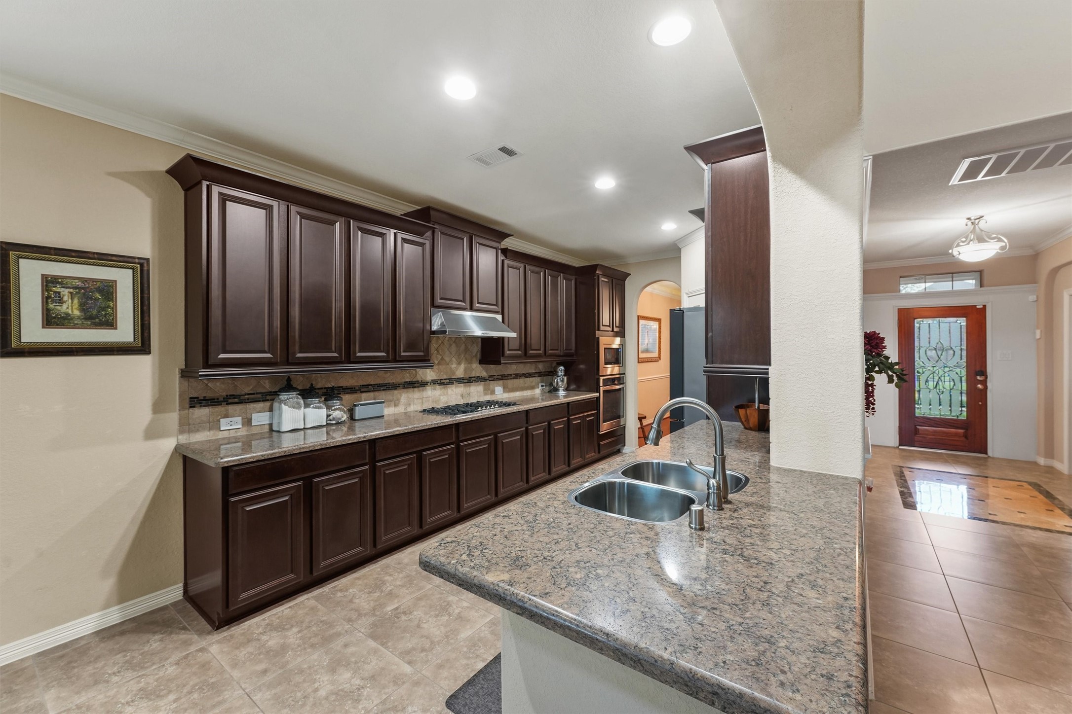 529 Water Street Webster, TX 77598 - Photo 7 of 38 a kitchen with kitchen island granite countertop a sink stove and cabinets