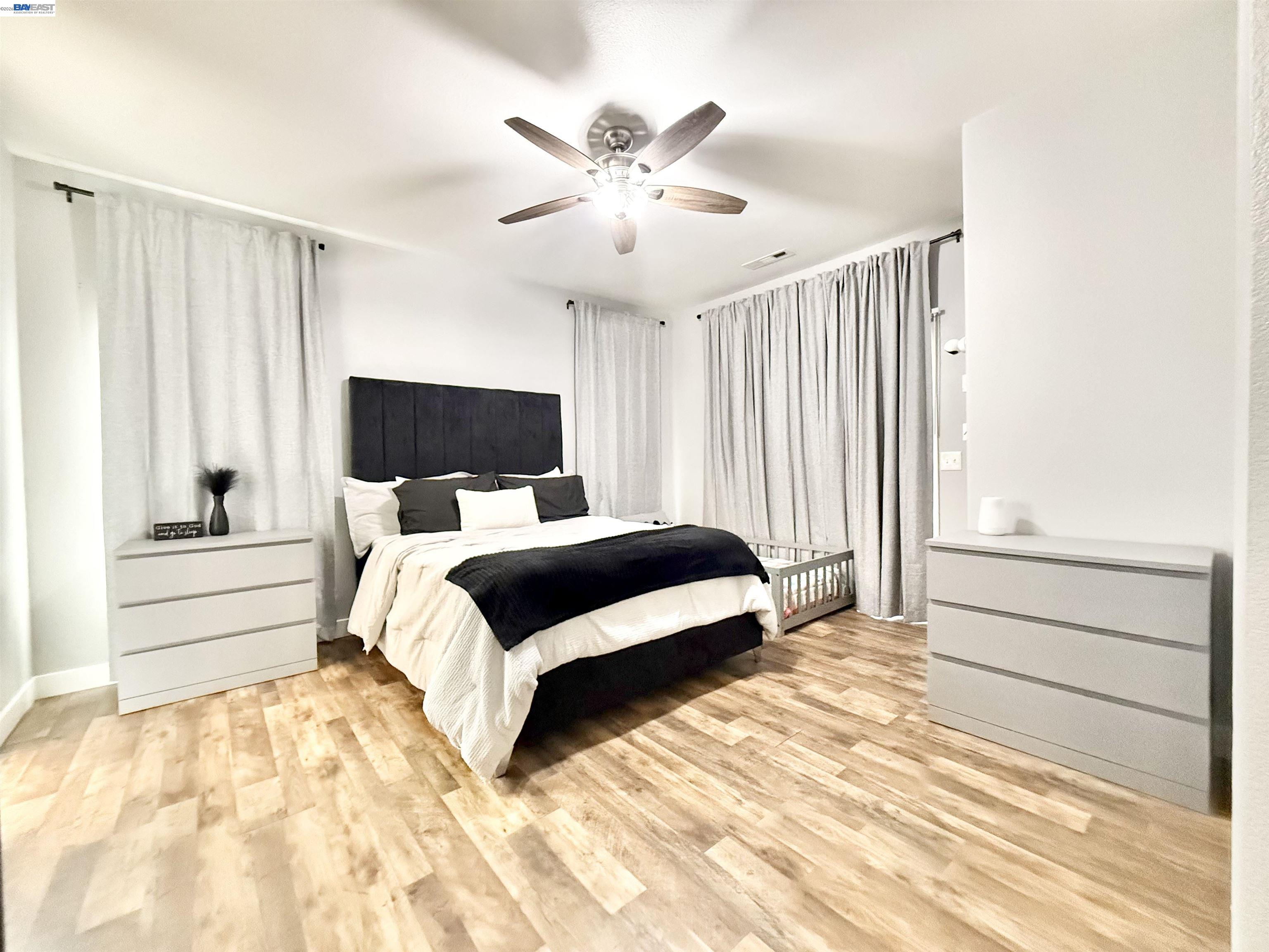 2408 Mountain Pride Court Modesto, CA 95355 - Photo 11 of 25 a bedroom with a large bed and a chandelier