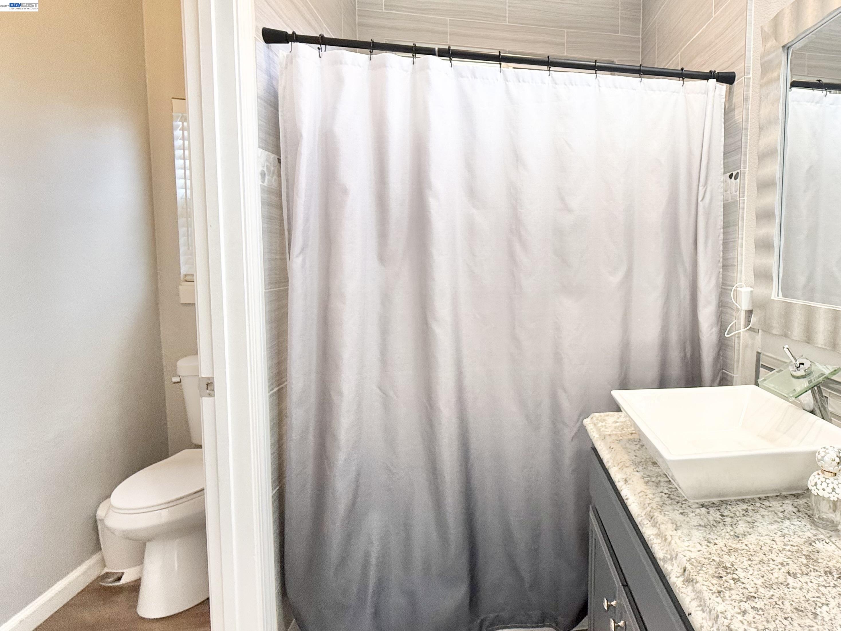 2408 Mountain Pride Court Modesto, CA 95355 - Photo 14 of 25 a bathroom with a granite countertop sink and a toilet