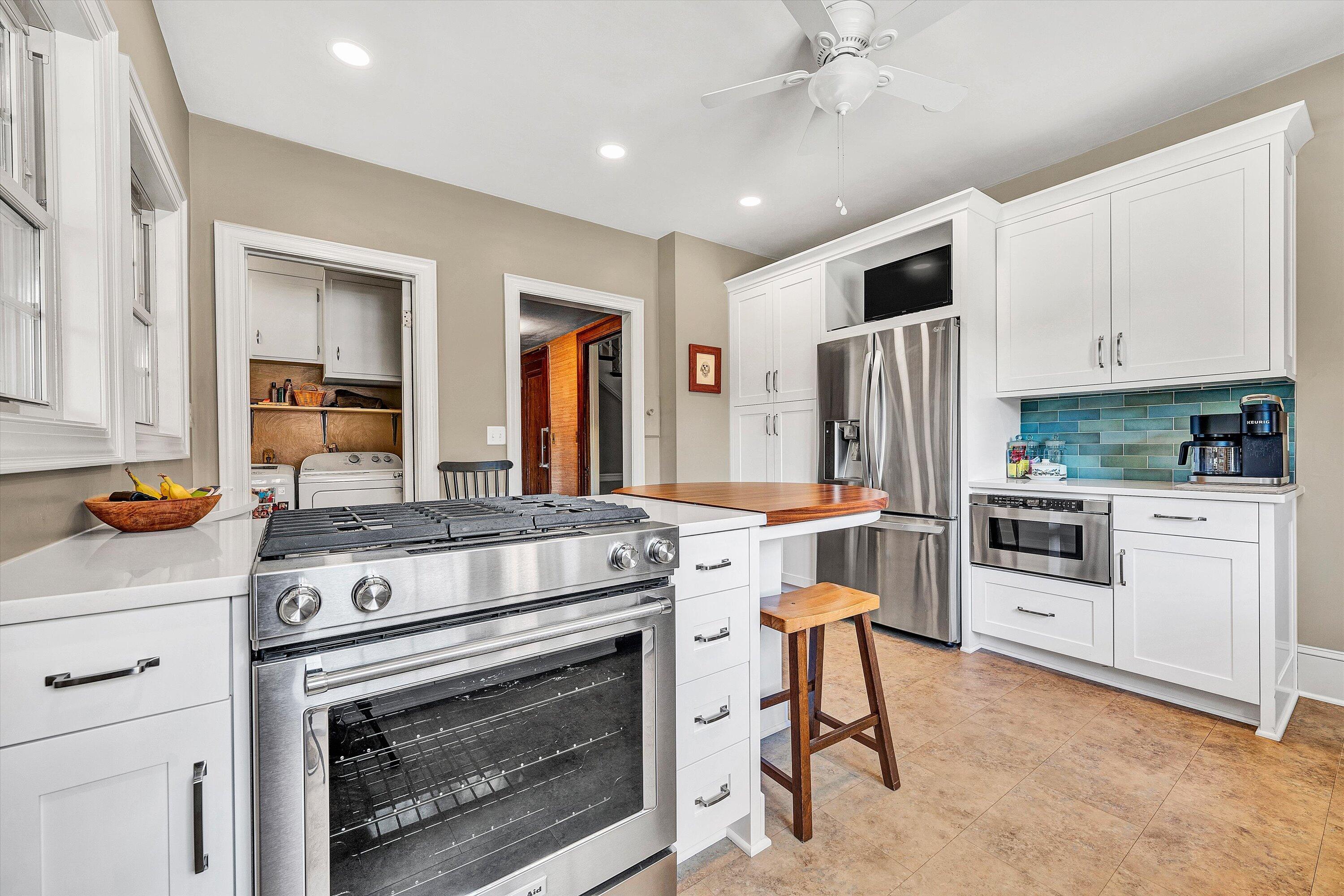 1930 Grandin Road Southwest Roanoke, VA 24015 - Photo 30 of 100 a kitchen with stainless steel appliances granite countertop a stove a refrigerator and a stove top oven with white cabinets