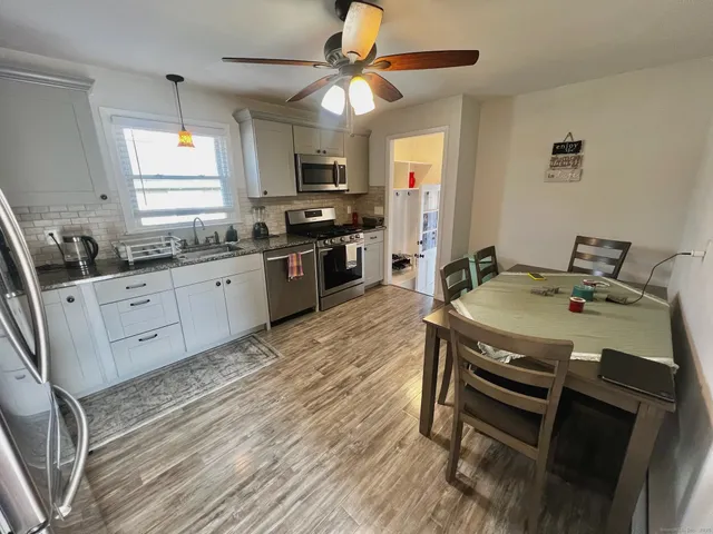 a kitchen with granite countertop a sink appliances counter top space and cabinets