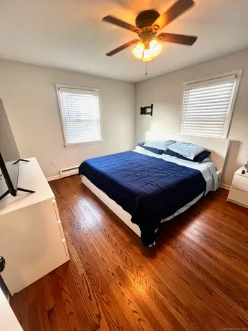 a bedroom with a bed and wooden floor