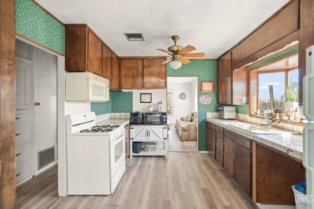 a kitchen with a stove a refrigerator and a clock