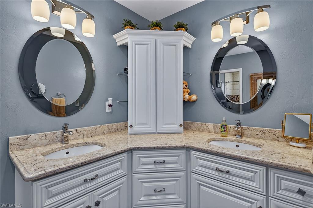 681 St Andrews Boulevard Naples, FL 34113 - Photo 11 of 20 a bathroom with a granite countertop double vanity sink and a mirror