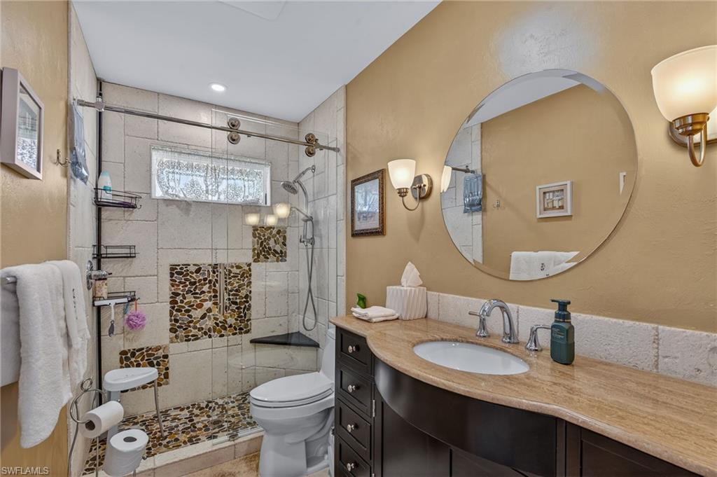 681 St Andrews Boulevard Naples, FL 34113 - Photo 13 of 20 a bathroom with a granite countertop toilet sink and mirror