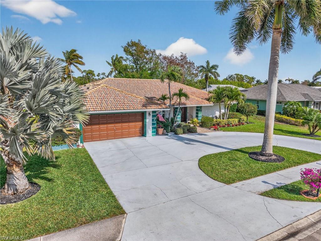 681 St Andrews Boulevard Naples, FL 34113 - Photo 2 of 20 a front view of a house with garden