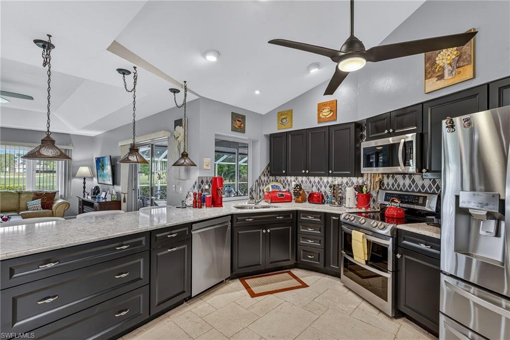 681 St Andrews Boulevard Naples, FL 34113 - Photo 5 of 20 a kitchen with stainless steel appliances kitchen island granite countertop a sink and cabinets