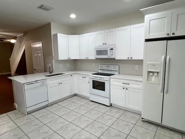 a kitchen with white cabinets stainless steel appliances and sink