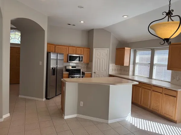 a kitchen with stainless steel appliances a refrigerator a stove a sink a microwave and dining table