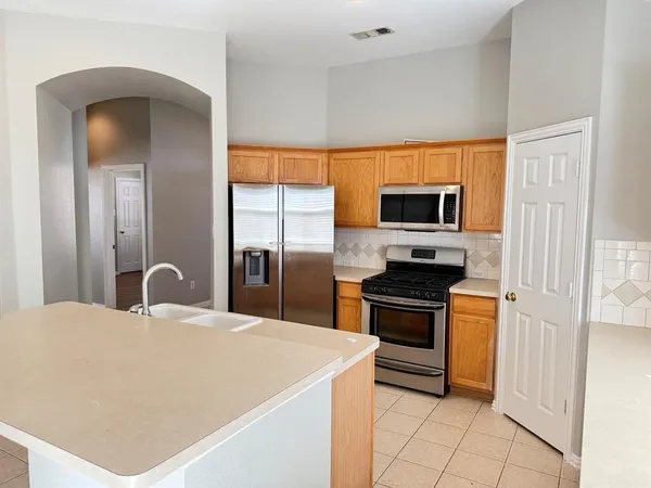 a kitchen with stainless steel appliances granite countertop a stove a sink and a refrigerator