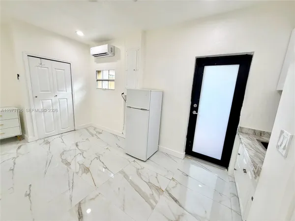 a view of a storage & utility room with refrigerator in kitchen
