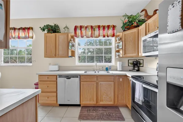 a kitchen with granite countertop a sink stainless steel appliances a counter space and cabinets