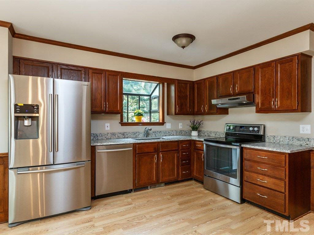 8501 Council Court Raleigh, NC 27615 - Photo 3 of 19 a kitchen with stainless steel appliances granite countertop a stove top oven a refrigerator and a sink with wooden cabinets