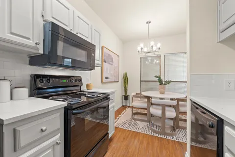 a kitchen with stainless steel appliances a stove sink and cabinets