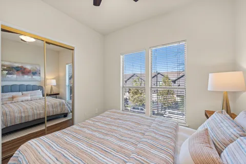 a bedroom with a bed and a large window