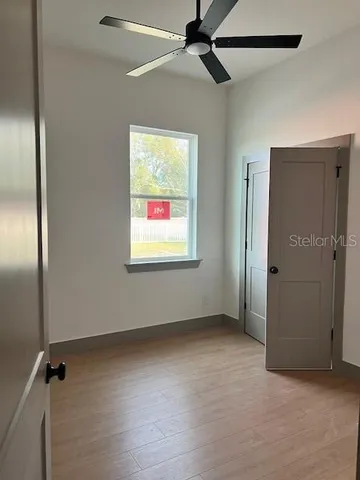 an empty room with windows & fan