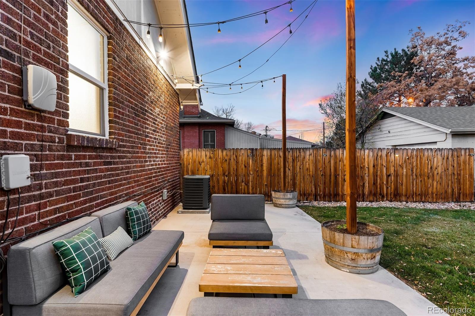 4270 Irving Street Denver, CO 80211 - Photo 31 of 34 a view of a patio with couches chairs potted plants and wooden fence