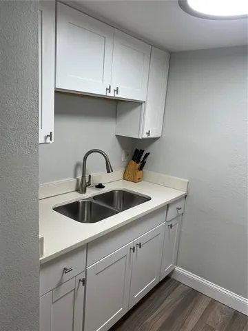 a close view of a sink and dishwasher with cabinets