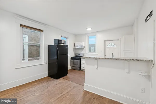 a view of a kitchen with refrigerator and window