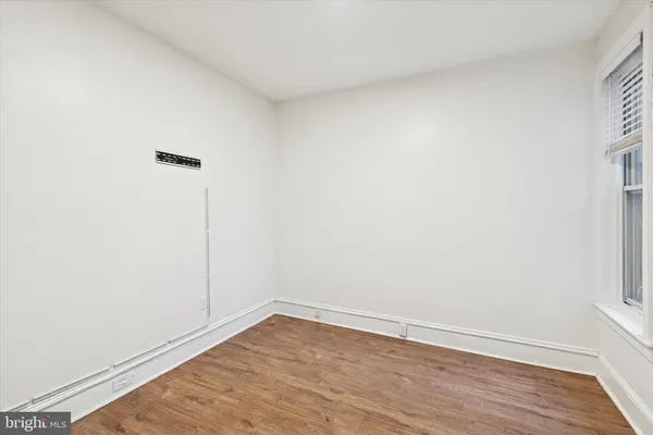 a view of an empty room with wooden floor