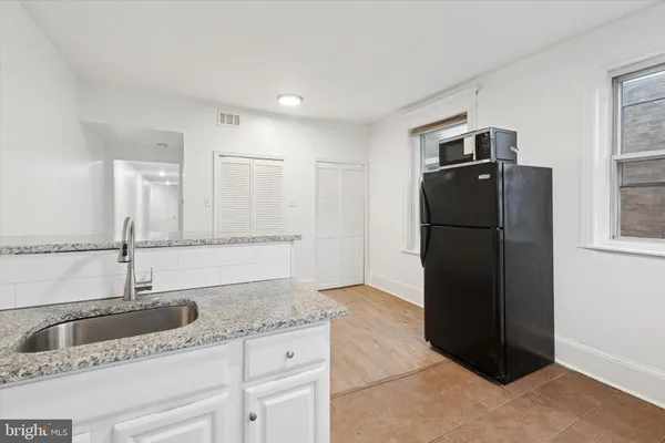 a kitchen with granite countertop a refrigerator and a sink