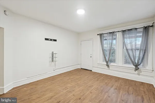 an empty room with wooden floor and door