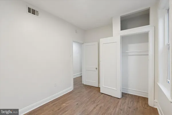 a view of an empty room with wooden floor