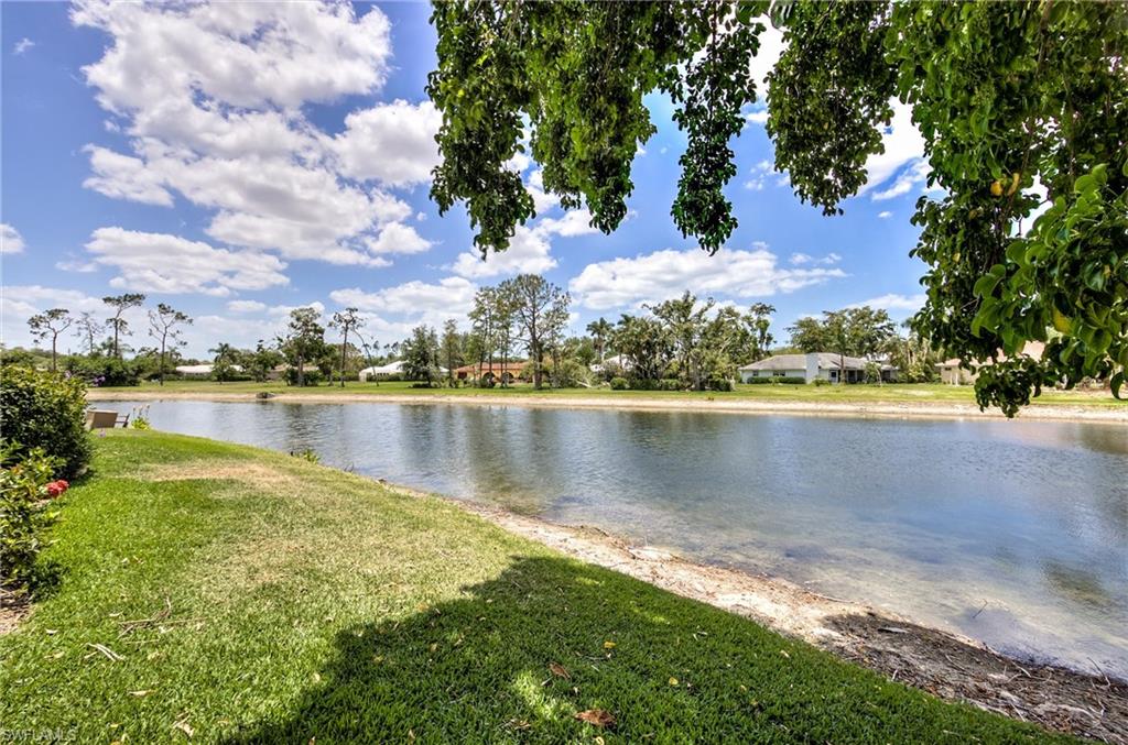 113 Bobolink Way, Unit 113B Naples, FL 34105 - Photo 14 of 15 a view of a lake with a big yard