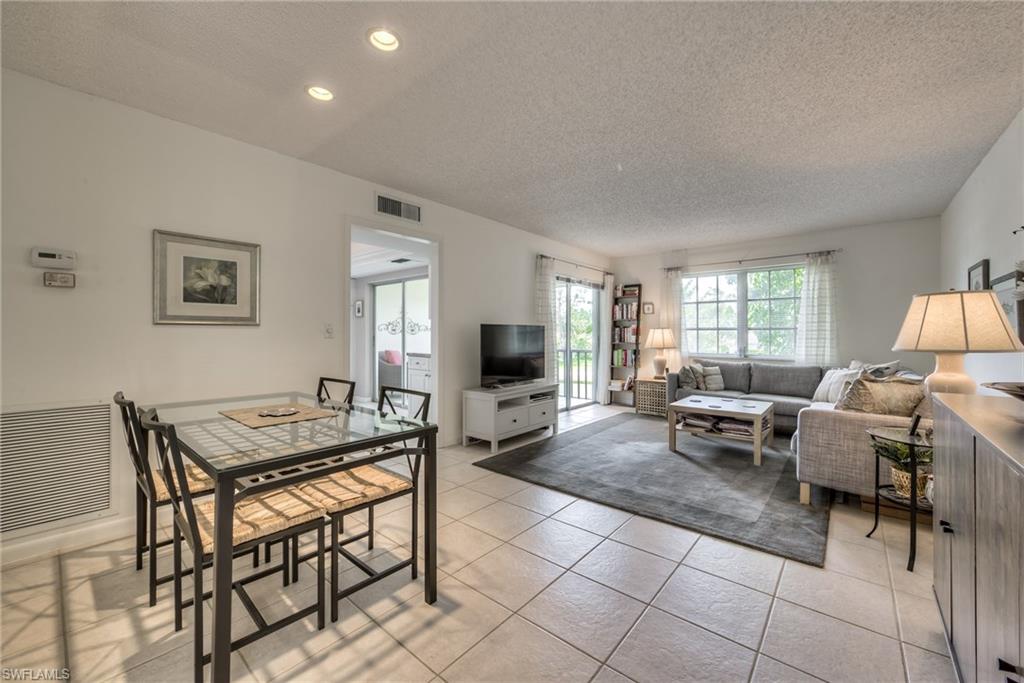 113 Bobolink Way, Unit 113B Naples, FL 34105 - Photo 2 of 15 a living room with furniture and a flat screen tv