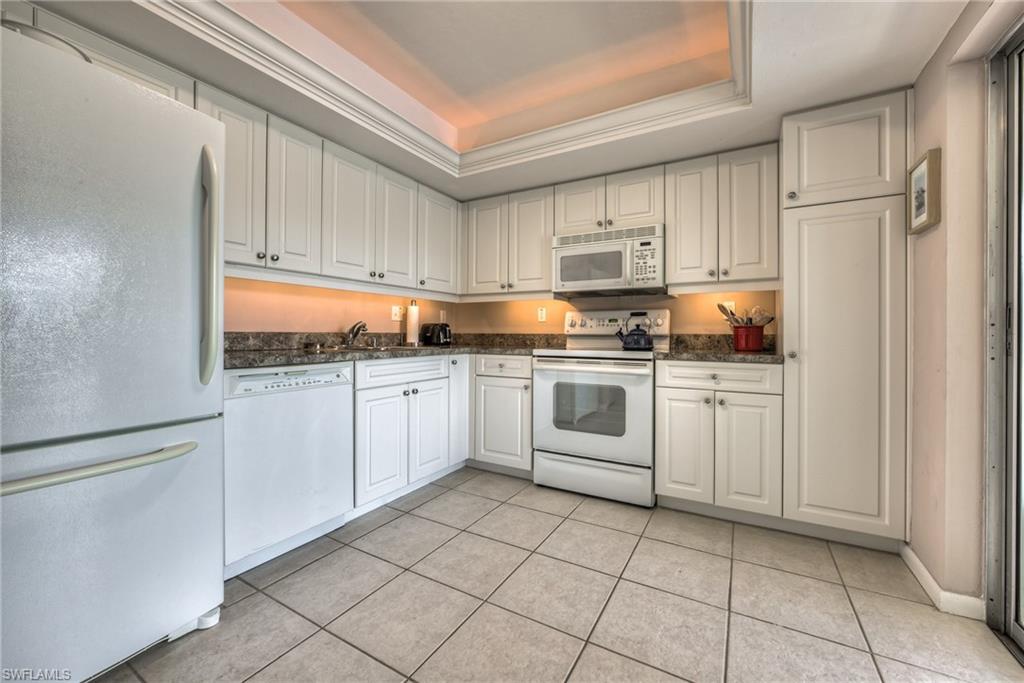 113 Bobolink Way, Unit 113B Naples, FL 34105 - Photo 6 of 15 a kitchen with white cabinets stainless steel appliances and sink