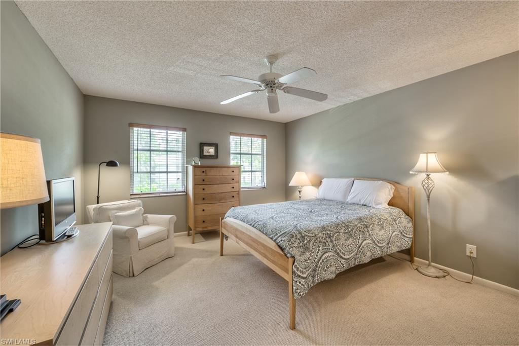 113 Bobolink Way, Unit 113B Naples, FL 34105 - Photo 8 of 15 a bedroom with a large bed and a flat tv screen