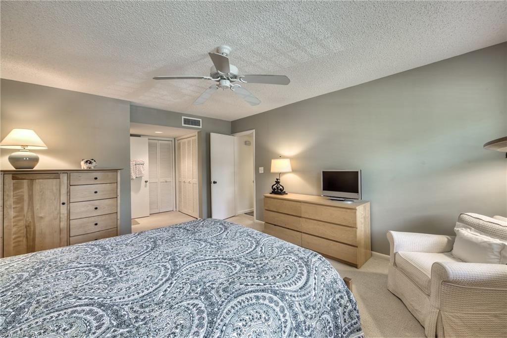 113 Bobolink Way, Unit 113B Naples, FL 34105 - Photo 9 of 15 a bedroom with a bed and a couch