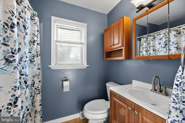 a bathroom with a granite countertop sink and a toilet