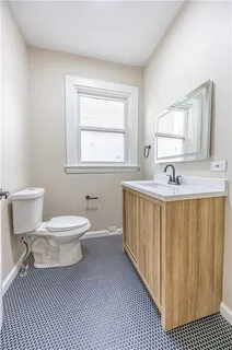 a bathroom with a granite countertop toilet sink and mirror