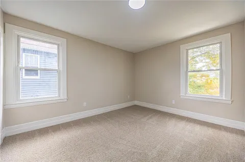 an empty room with closet and windows