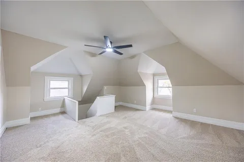 an empty room with windows and ceiling fan