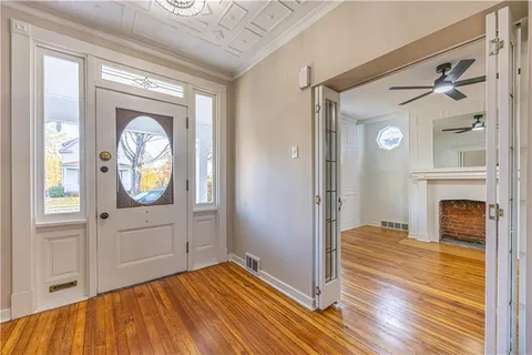 a view of a livingroom with wooden floor and a fireplace