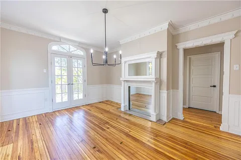 a view of empty room with wooden floor and fireplace