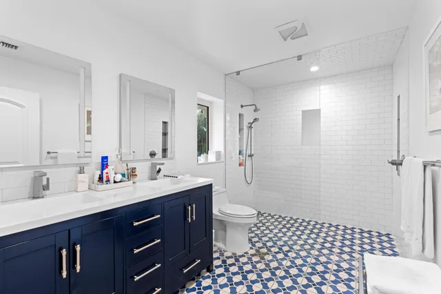 a bathroom with a sink a toilet a shower and a mirror