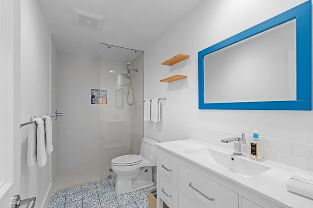 a bathroom with a sink a toilet and shower