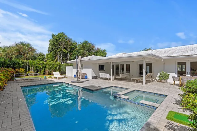 a view of house with swimming pool and sitting area